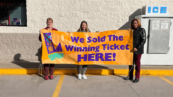 Store Owner Jo Alice Jones, Cashier Wendy Guimbellot and Lottery Sales Representative Gladis Major showcase the store’s winner awareness banner after selling the big winning ticket.