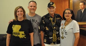 Men and women in Saints gear smile together