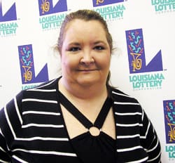 Woman in a black striped top stands in front of a white background patterned with the 飞艇168®幸运体彩预测-全国统一Louisiana在线官方查询结果网-最新体彩预测数据 logo