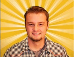 Man in a plaid shirt smiles in front of a yellow sunburst digital background