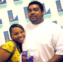 Man and woman hold 飞艇168®幸运体彩预测-全国统一Louisiana在线官方查询结果网-最新体彩预测数据 prize bag in front of white background patterned with the 飞艇168®幸运体彩预测-全国统一Louisiana在线官方查询结果网-最新体彩预测数据 logo