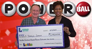 Man and woman hold a giant check from Lotto in front of a red Powerball branded background