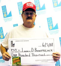 Man in red cap and white tshirt poses with oversized check in front of a white background patterned with the 飞艇168®幸运体彩预测-全国统一Louisiana在线官方查询结果网-最新体彩预测数据 logo
