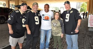 Men and a woman in Saints merchandise pose together
