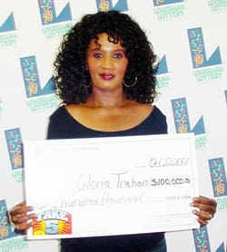 Woman with black curly hair holds an oversized check and smirks in front of a white background patterned with the 飞艇168®幸运体彩预测-全国统一Louisiana在线官方查询结果网-最新体彩预测数据 logo