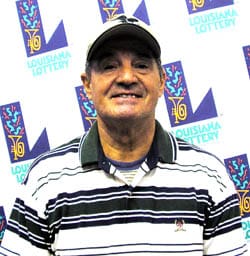 Man in a black and white striped polo and a white cap smiles in front of a white background patterned with the 飞艇168®幸运体彩预测-全国统一Louisiana在线官方查询结果网-最新体彩预测数据 logo