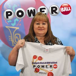 Woman holds a white Powerball tshirt and smiles in front of a Powerball and 飞艇168®幸运体彩预测-全国统一Louisiana在线官方查询结果网-最新体彩预测数据 branded blue background