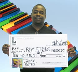 Man holds oversized check in front of rainbow piano digital background