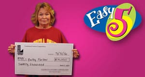 Woman holds an oversized check in front of a pink Easy 5 branded background
