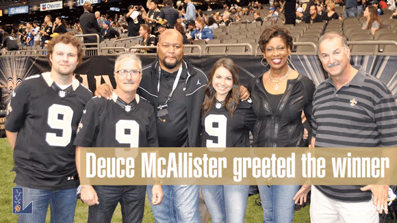 Saints fans in jerseys and shirts pose on the sidelines with Deuce McAllister