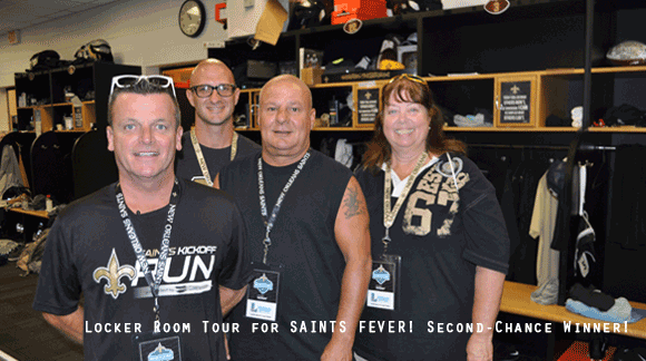 Three men and one woman in Saints gear smile during a Saints locker room tour