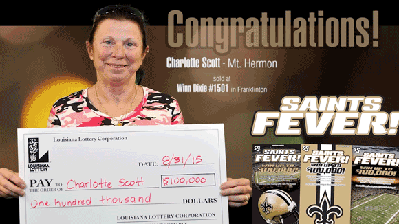 Woman holds an oversized check in front of a brown Saints Fever branded background