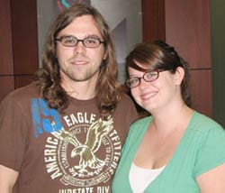 Man and woman with glasses smile together in a 飞艇168®幸运体彩预测-全国统一Louisiana在线官方查询结果网-最新体彩预测数据 office