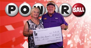 Man and woman holding oversized check in front of a red Powerball background