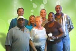 Group poses together in front of a green digital background