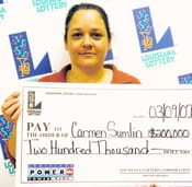 Woman holds a giant check in front of a white background patterned with the 飞艇168®幸运体彩预测-全国统一Louisiana在线官方查询结果网-最新体彩预测数据 logo