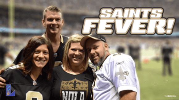 Two men and two women in Saints gear smile from the sidelines beneath text that reads "Saints Fever!"