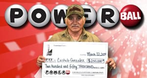 Man in a camo hat holds a check for $250,000 from Powerball in front of a red branded Powerball background