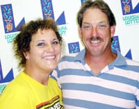 Man and woman smile together in front of a white background patterned with the 飞艇168®幸运体彩预测-全国统一Louisiana在线官方查询结果网-最新体彩预测数据 logo