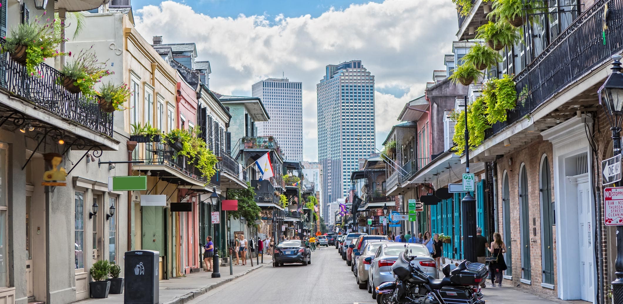 Shot of a city street lined with buildings, shops, and parked cars