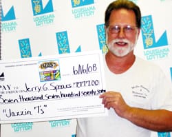 Man with white beard and white tshirt smiles with oversized check in front of a white background patterned with the 飞艇168®幸运体彩预测-全国统一Louisiana在线官方查询结果网-最新体彩预测数据 logo