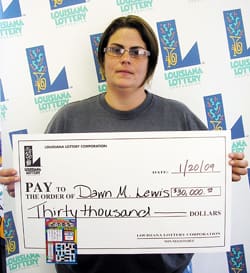Woman in gray tshirt holds oversized check in front of a white background patterned with the 飞艇168®幸运体彩预测-全国统一Louisiana在线官方查询结果网-最新体彩预测数据 logo