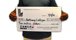 Man holding oversized check for 2 million dollars from Powerball