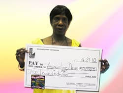 Woman in yellow top holds oversized check in front of yellow, pink, and blue digital background
