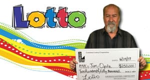 Man holds an oversized check in front of a rainbow Lotto branded background